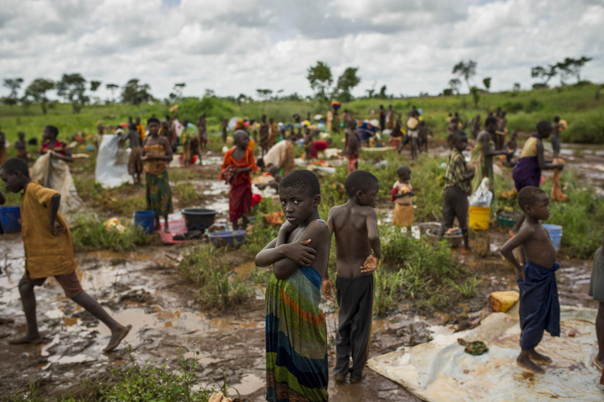 A Burundian refugee is pictured as others wash clothes near a river on the edge of the Nyarugusu refugee camp in Tanzania on March 26, 2016. According to UNHCR, Nyarugusu is "one of the largest and most overcrowded refugee camps in the world", currently hosting over 140,000 refugees but built to accommodate only 50,000. The camp has a resident population of around 60,000 Congolese refugees, with an influx of around 78,000 Burundian refugees since last year.